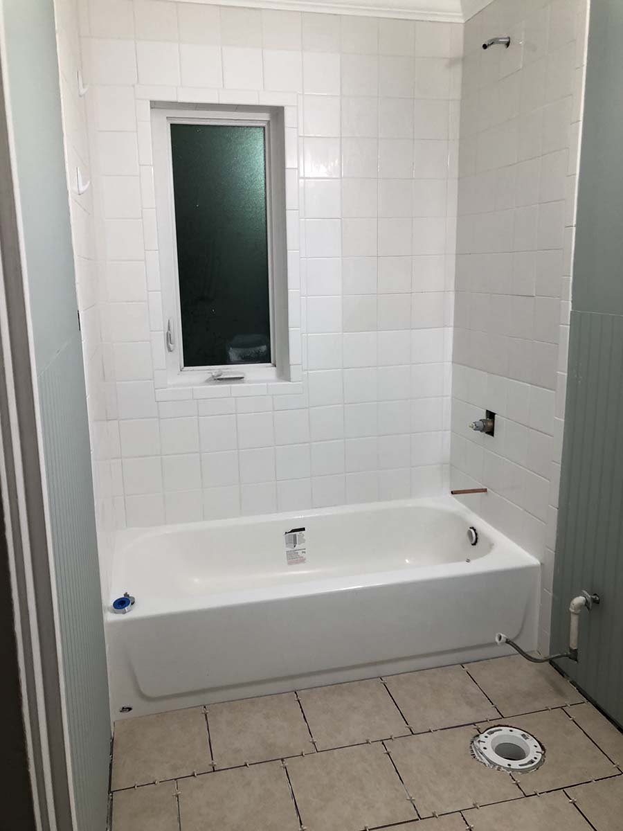 Project Note: The variance in the white wall tile is due to the age of the existing tile. The owner chose to just correct the water damaged areas and not to replace all the tile.