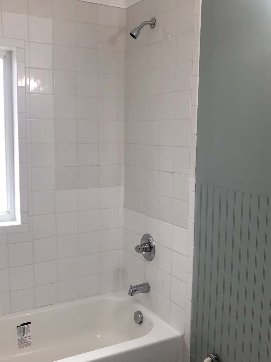 Project Note: The variance in the white wall tile is due to the age of the existing tile. The owner chose to just correct the water damaged areas and not to replace all the tile.